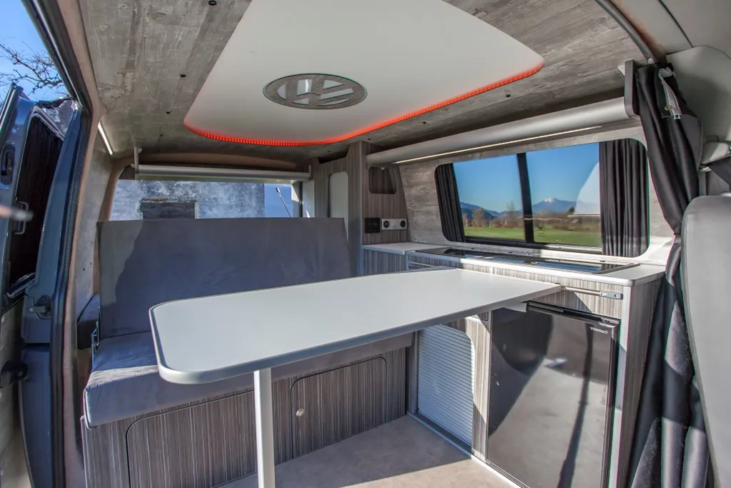 Aménagement intérieur sur-mesure VW Transporter T6 L1H1 avec plafonnier signature logo VW rétroéclairé à Paris et en Île-de-France