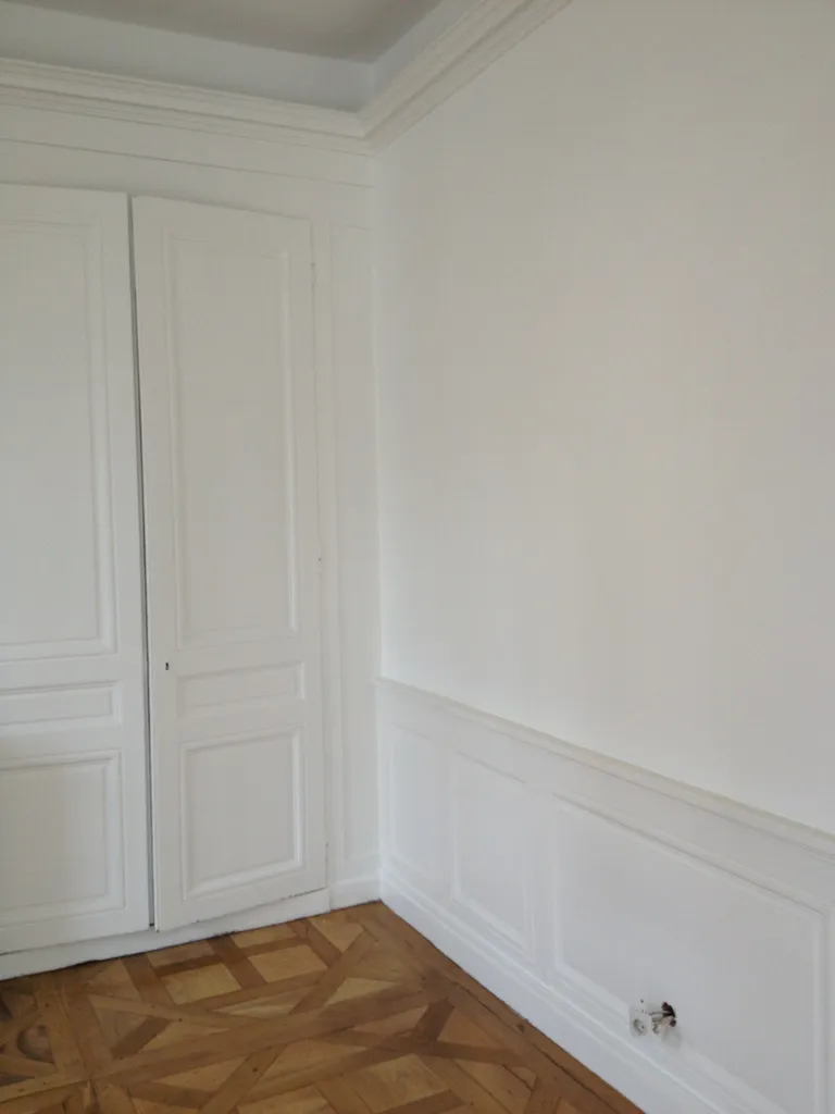 Rénovation intérieure avec peinture des placards, soubassements remis en état et parquet massif restauré dans un appartement haussmannien