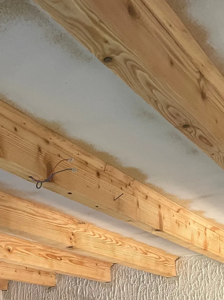 Poutre en résineux après sablage par aérogommage à Gleizé dans le Beaujolais, révélant le bois naturel et le veinage d’origine.