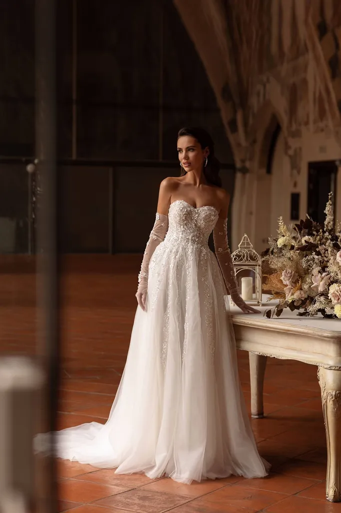 Robe de mariée trapèze bustier orné de sequins, gants en tulle transparent brodés de fleurs 3D et de perles scintillantes à Marseille Vieux port