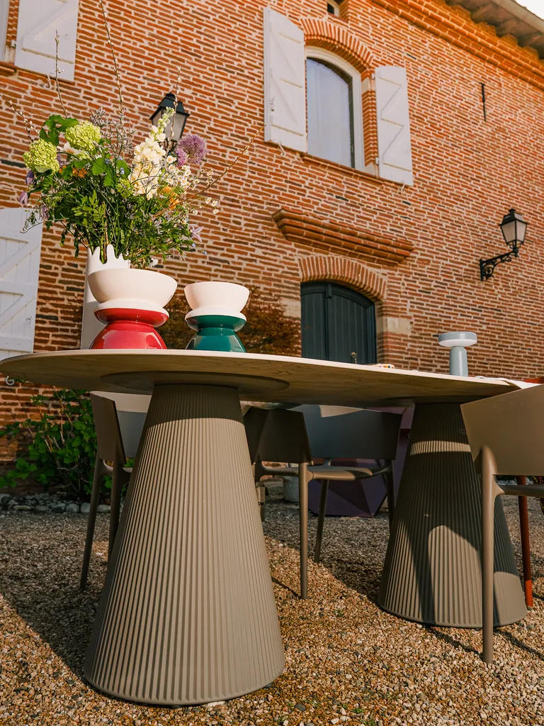 Gatsby, table à dîner ovale ou rectangulaire en résine et polypropylène signée Vondom, avec finitions effet marbre ou travertin pour un style élégant et contemporain.
