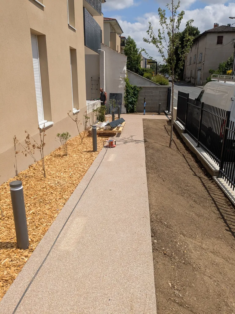 Pose de clôture à barreaudage avec plantation au pied avec paillage et engazonnement à l'entrée d'une copropriété à Jassans-Riottier proche de Villefranche-sur-Saône