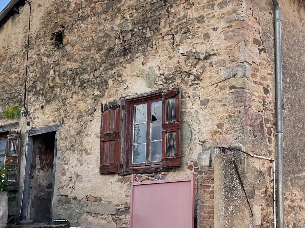 Fenêtre ancienne avant rénovation dans une maison en pierre et pisé à Chiroubles (Rhône 69) générant des pertes de chaleur
