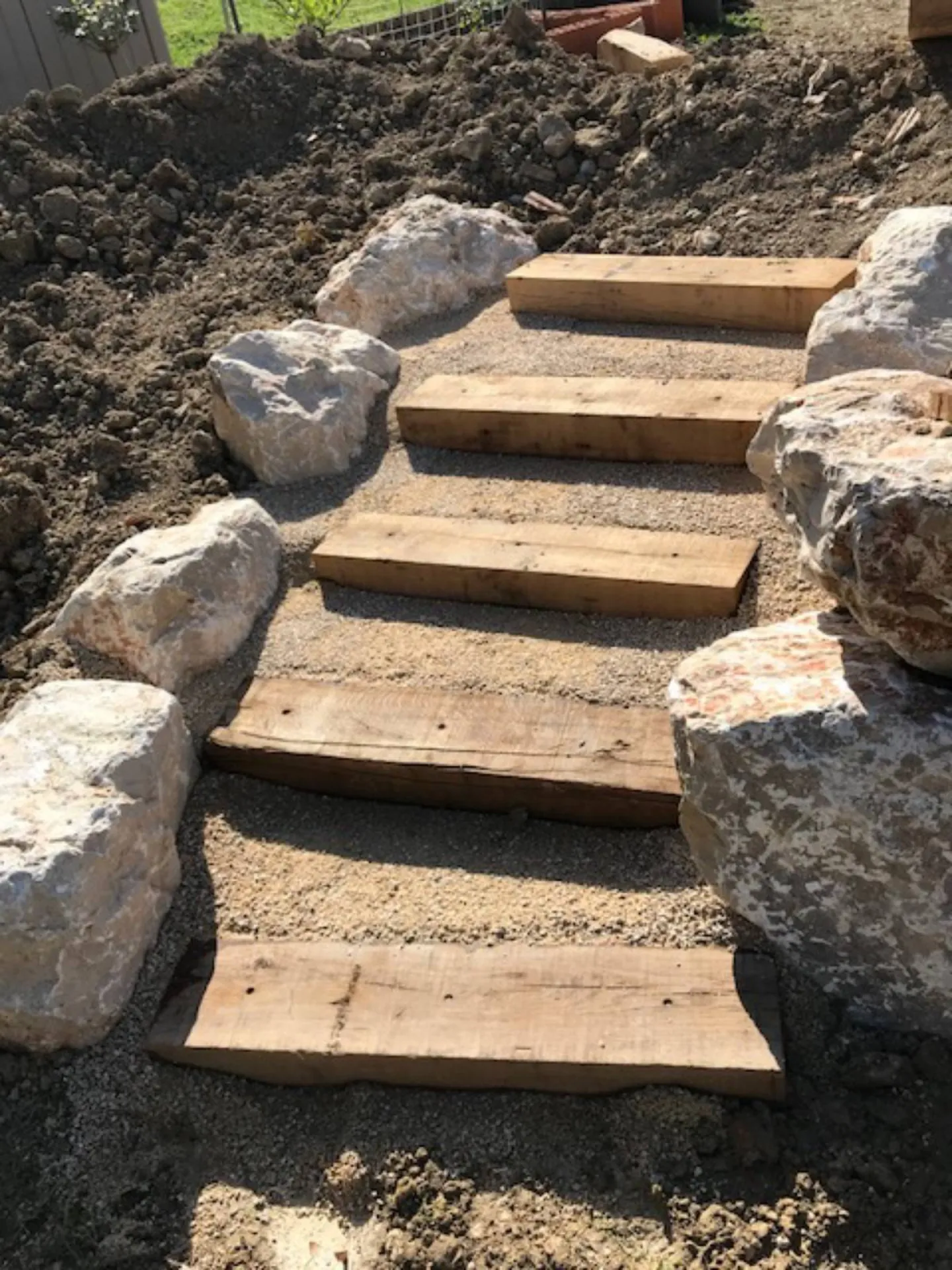 Enrochement d’un terrain en pente autour d’une terrasse en bois composite à Ventabren