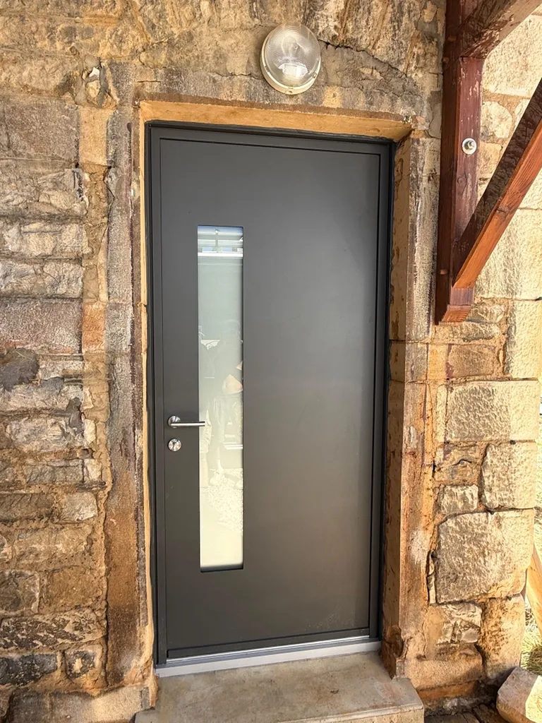 Fourniture et pose d'une porte d'entrée en aluminium dans un mur en pierres dorées à Villefranche sur Sâone