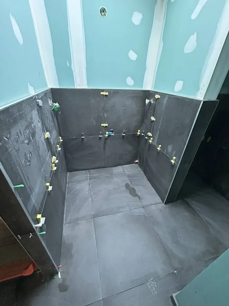 Pose de carrelage dans la seconde salle de bain avec finitions soignées