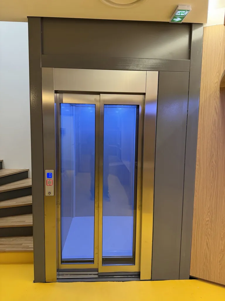 Portes inox télescopiques vitrées pour cet élévateur VIMEC 100% électrique dans cet ERP à Nice