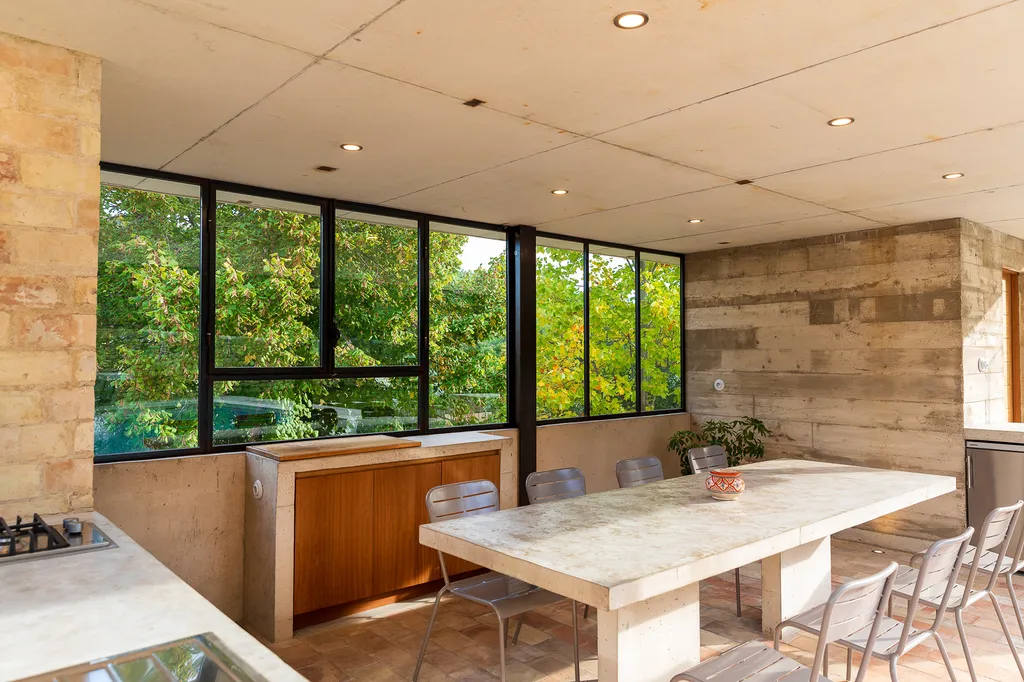 Cuisine extérieure contemporaine en béton avec mobilier sur mesure et grandes ouvertures vitrées en Provence