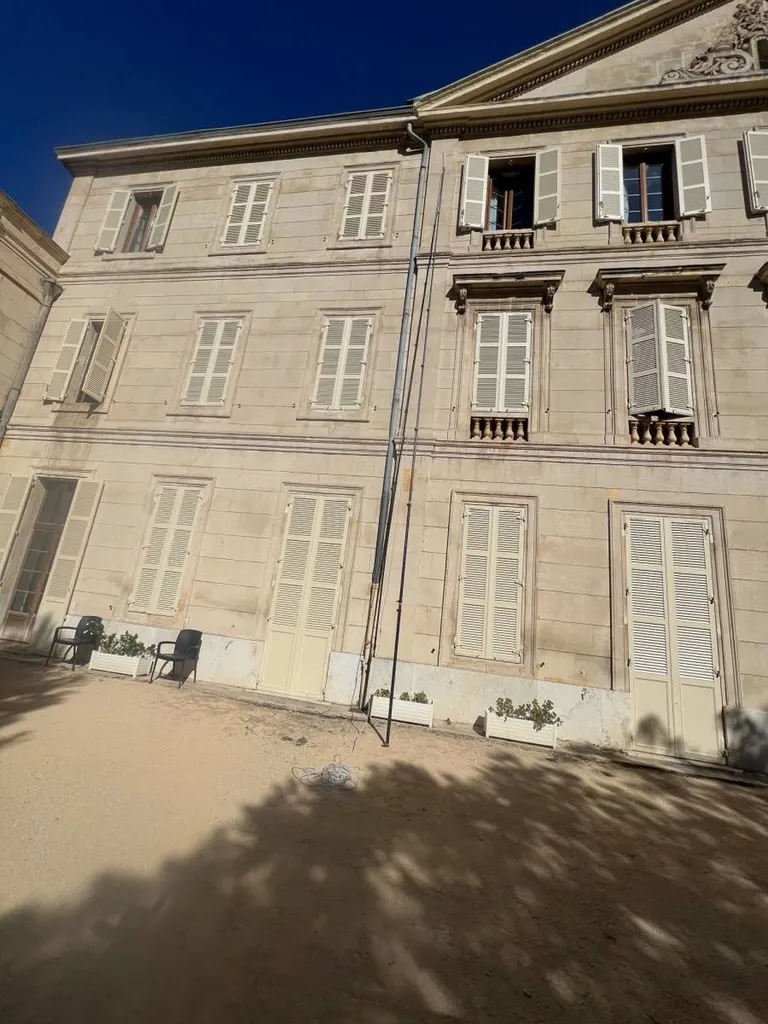 Traitement d'un nid de frelons asiatiques avec l'utilisation d'une perche télescopique sur la façade d'une maison de retraite à Marseille dans les Bouches du Rhone