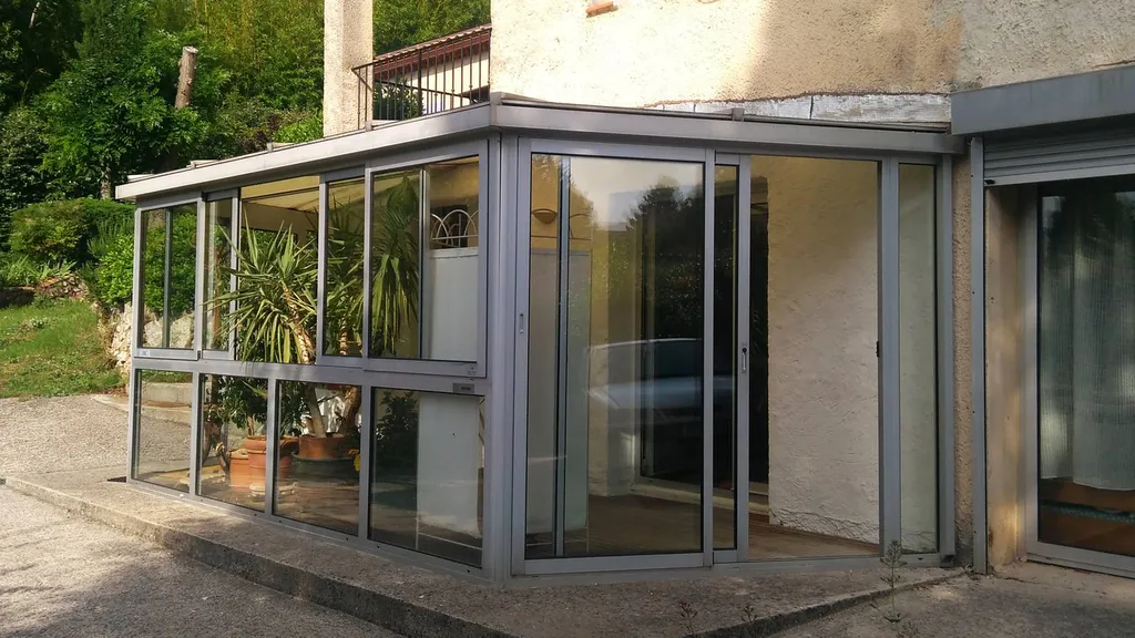 Pose d'une véranda en aluminium de marque Technal de couleur grise près de Marseille