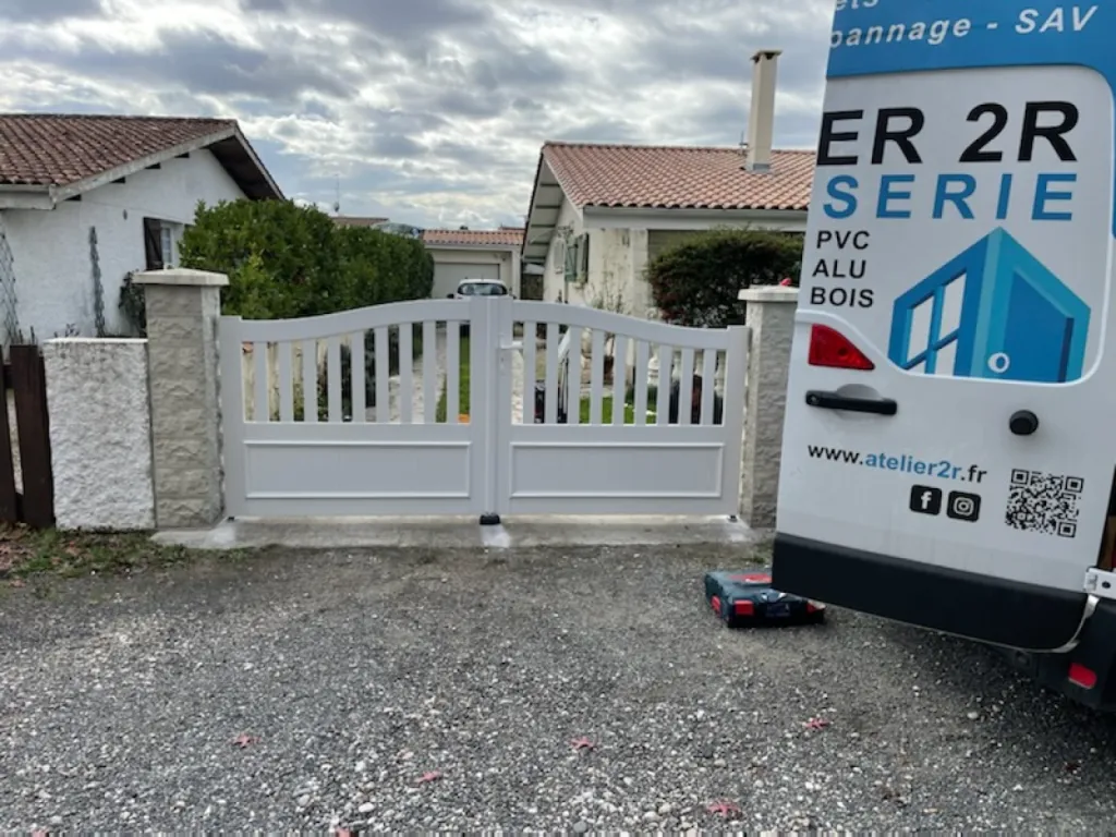 Installation d’un portail battant en aluminium blanc avec ouverture centrale en deux parties à Créon