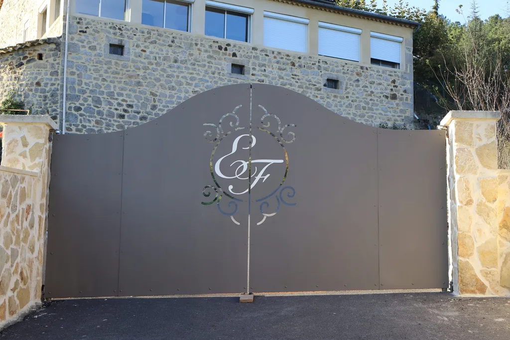 Portail en fer, avec initial incorporée au centre pour une entrée de propriété unique en Sud Ardèche.