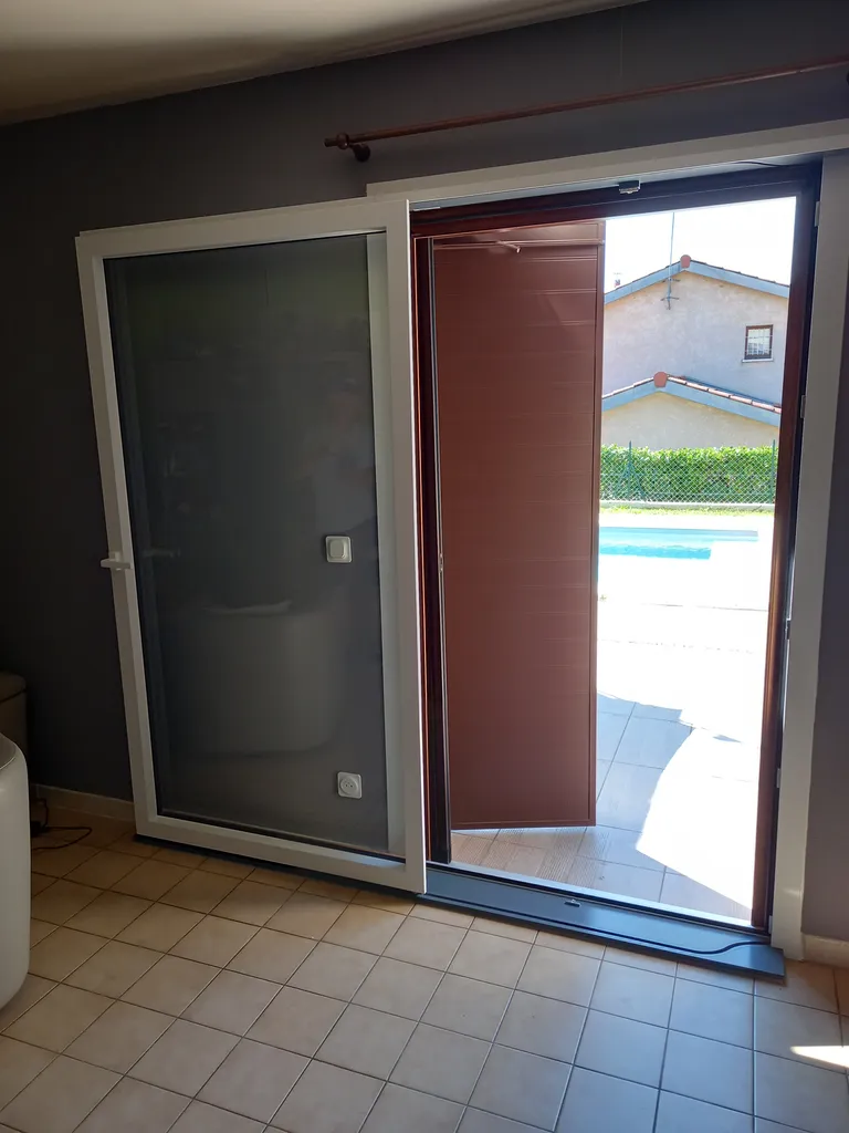 Installation d'un coulissant mural en aluminium s'escamotant devant le mur intérieur pour passage libre total à Pommiers