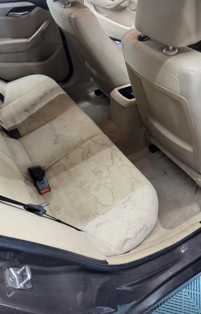 Nettoyage en profondeur des tissus blanc de siège arrière d'une voiture Renault Megane pour rattraper la couleur et redonner une nouvelle jeunesse à Genève en Suisse