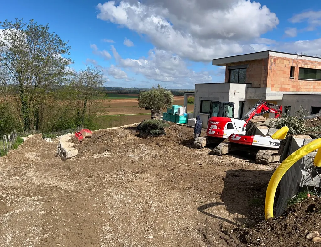 Aménagement extérieur complet à Cailloux-sur-Fontaines : terrassement, mur de soutènement en enrochement et empierrement de cour de maison contemporaine
