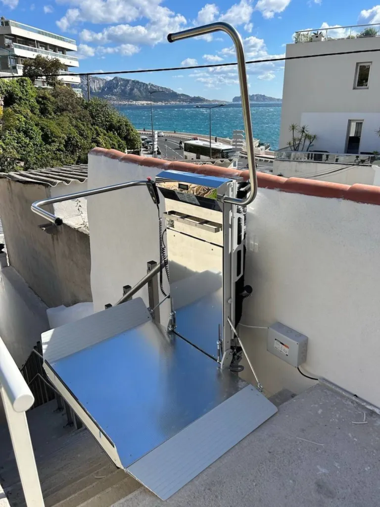 Un écrin pour cette plateforme oblique Lehner Stratos en extérieur dans un escalier droit avec palier intermédiaire à proximité de la mer à Marseille