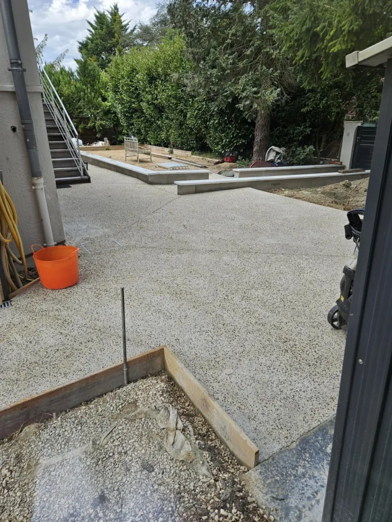 Conception d'une cour complète en béton désactiver avec des chemins d'accès jusqu'à l'escalier extérieur et la cabane de jardin à Meximieux dans l'Ain
