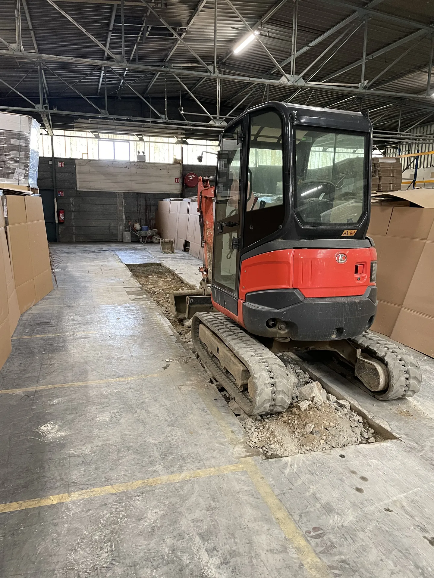 Terrassement et préparation de la zone endommagée lors de la réparation du sol en béton dans un entrepôt à Belleville-en-Beaujolais (Rhône – 69)