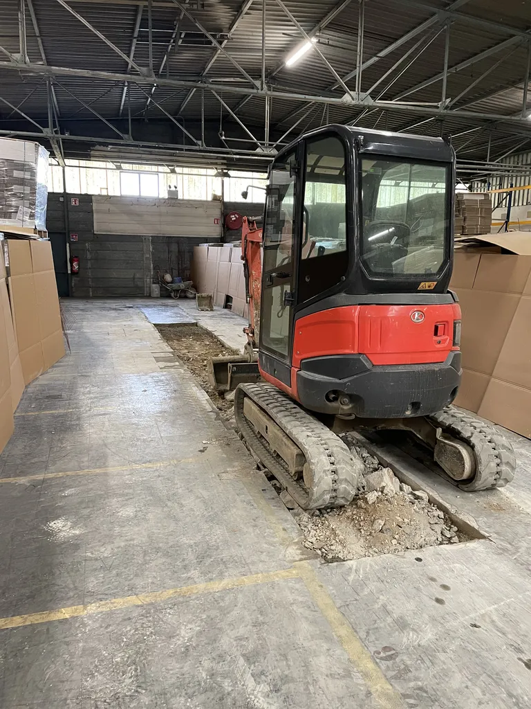 Terrassement et préparation de la zone endommagée lors de la réparation du sol en béton dans un entrepôt à Belleville-en-Beaujolais (Rhône – 69)