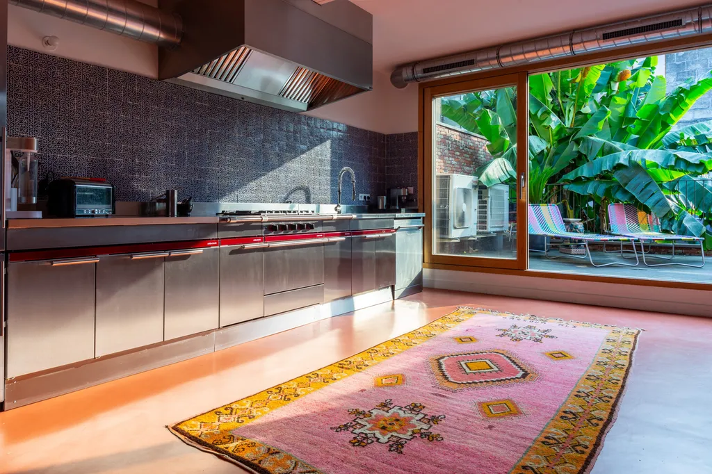 Cuisine en inox et crédence en mosaïque redessinée par AKIKO ARCHITECTURE, mêlant matières brutes et lumière naturelle dans ce projet Nansouty