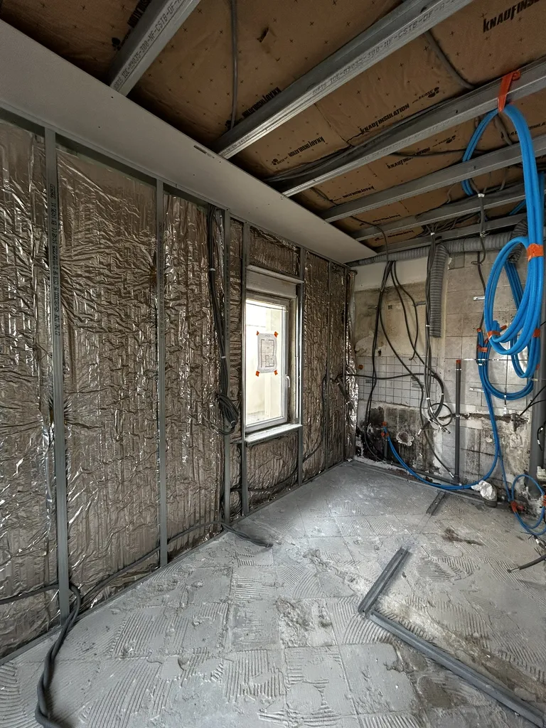 Pose de l'isolation alvéolaire haute performance Actis Hybris sur les murs extérieurs et encastrement sécurisé du nouveau réseau électrique
