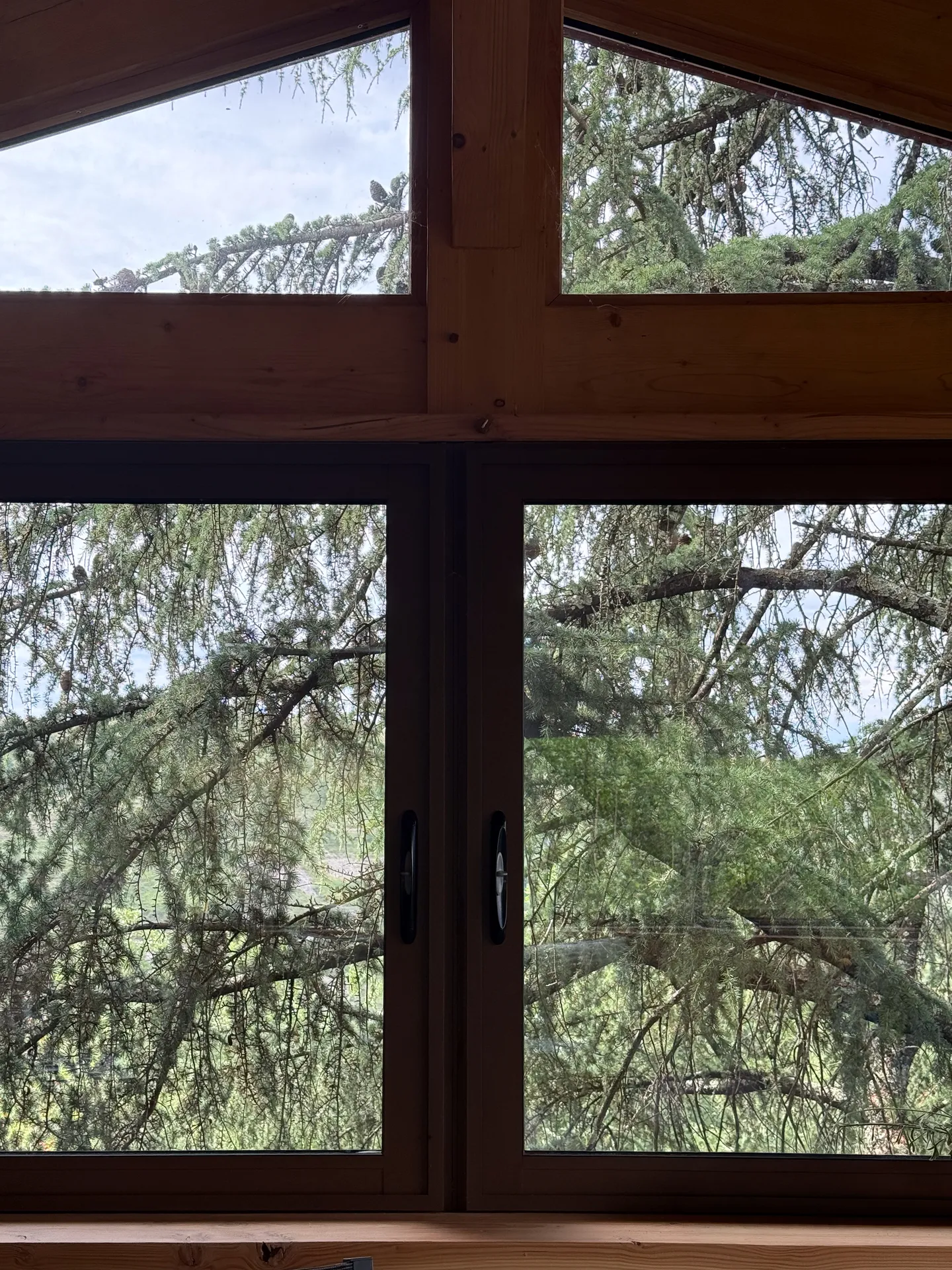 Fermeture d'une terrasse ardéchoise sous charpente bois avec de grands coulissants aluminium teinte rouille