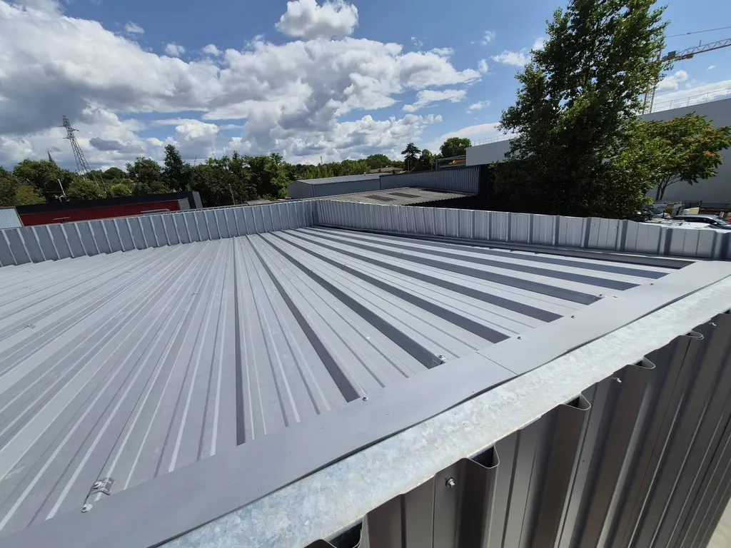 Chéneau sur mesure en tôle pliée aluminium, parfaitement intégré à la structure.