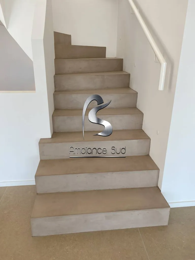 Habillage d’un escalier en béton brut avec du béton ciré taloché dans une maison neuve à Sainte Maxime