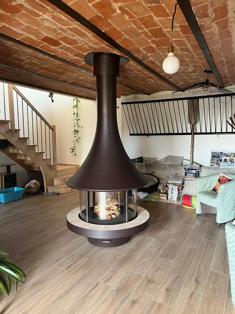 Cheminée centrale Bordelet EVA 992 dans un intérieur avec plafond brique et sol en parquet de bois