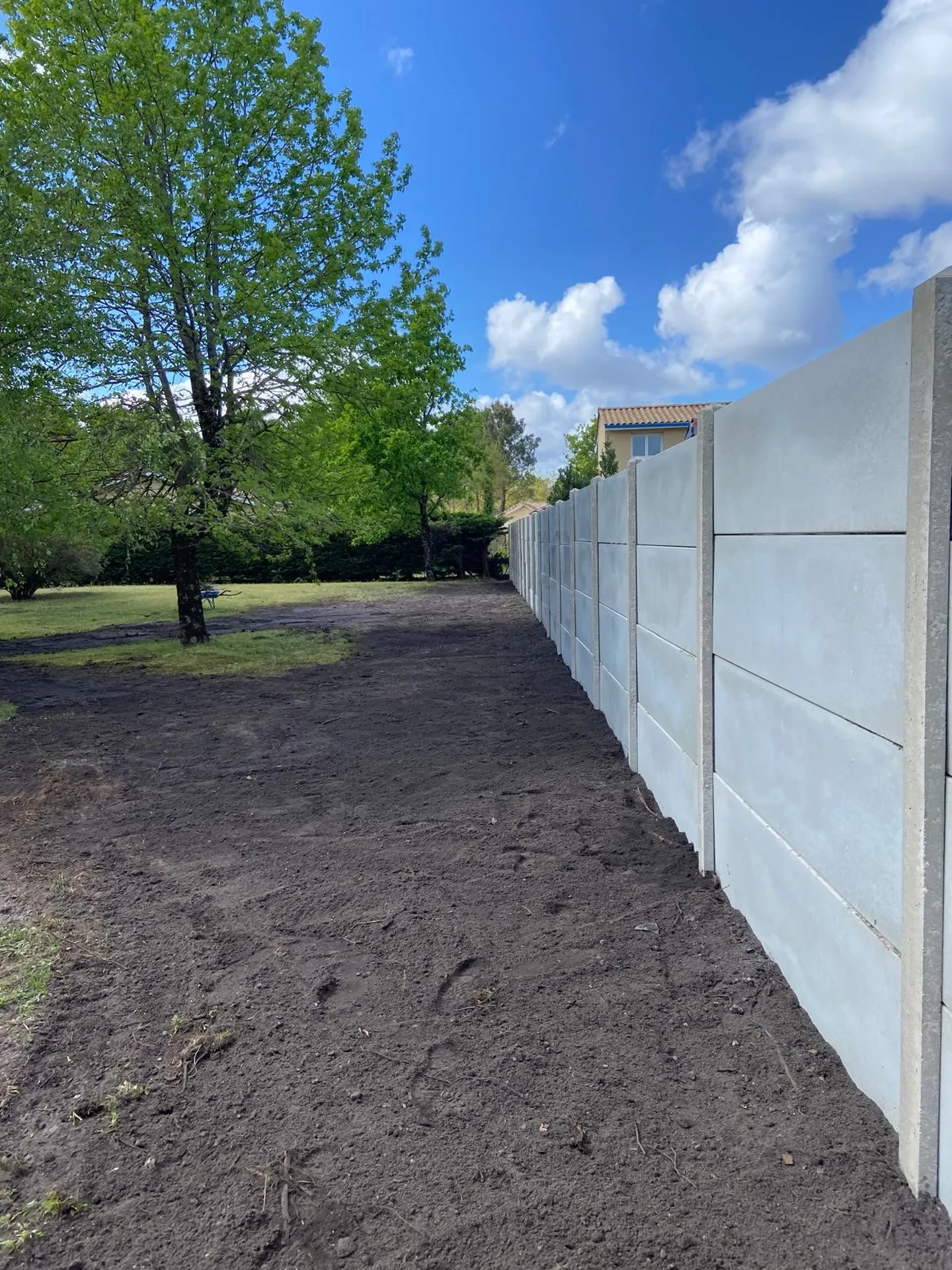 Réalisation d'une clôture en poteaux et plaques béton et terrassement du terrain sur la commune de Hourtin.