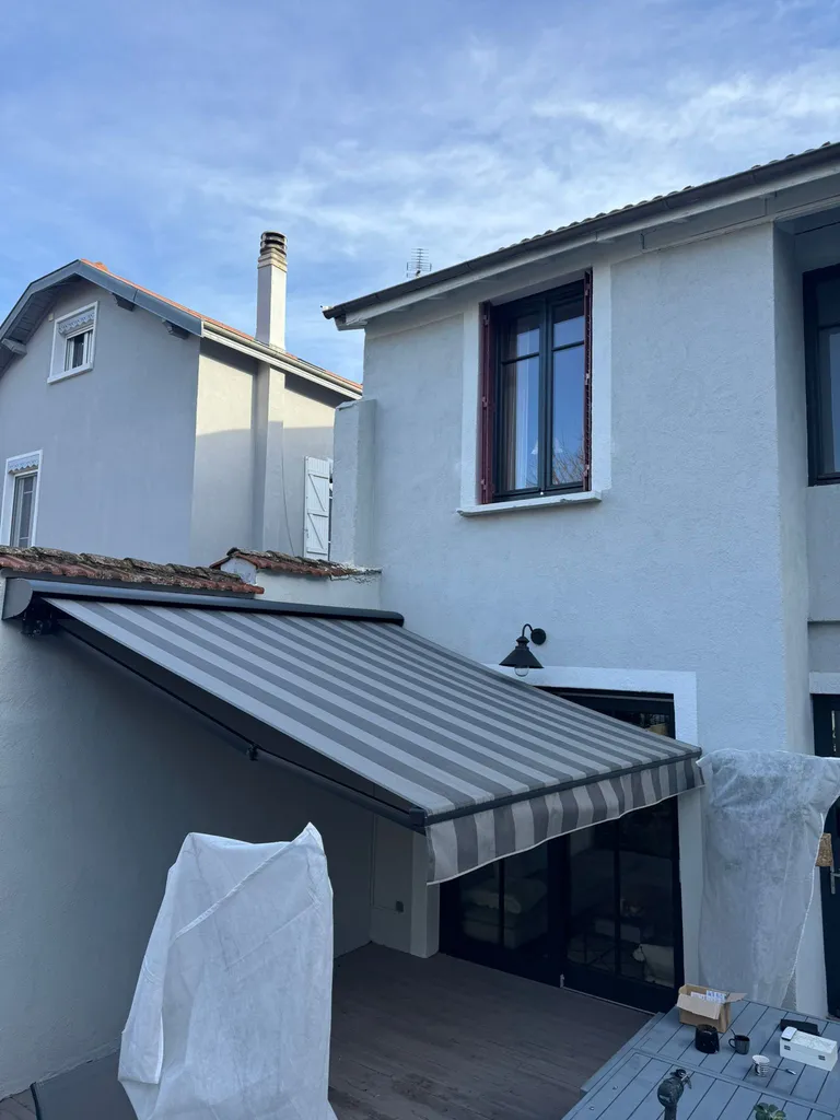 Pose d’un store Franciaflex motorisé sur mesure au-dessus d'une terrasse de maison dans un petit espace à Villeurbanne