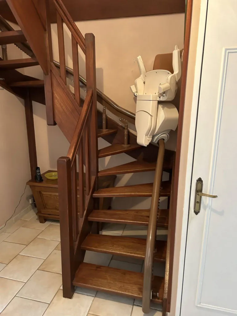 Une fois sur son point de charge l'espace est totalement dégagé avec l'installation de ce fauteuil monte escalier OTOLIFT Modul'Air Smart en intérieur dans un escalier étroit 2/4 tournant à Marseille