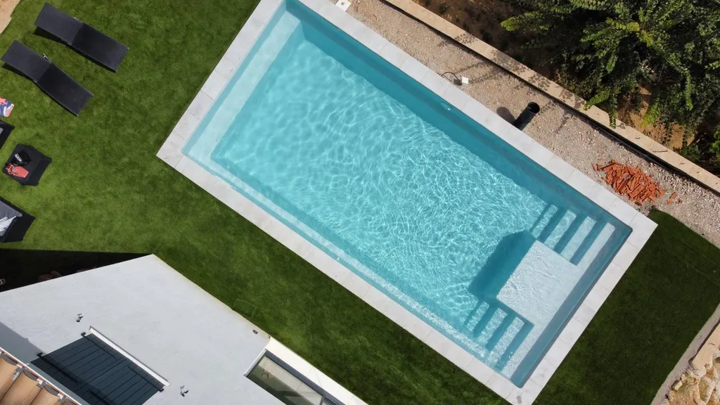 Piscine avec margelle dans pelouse