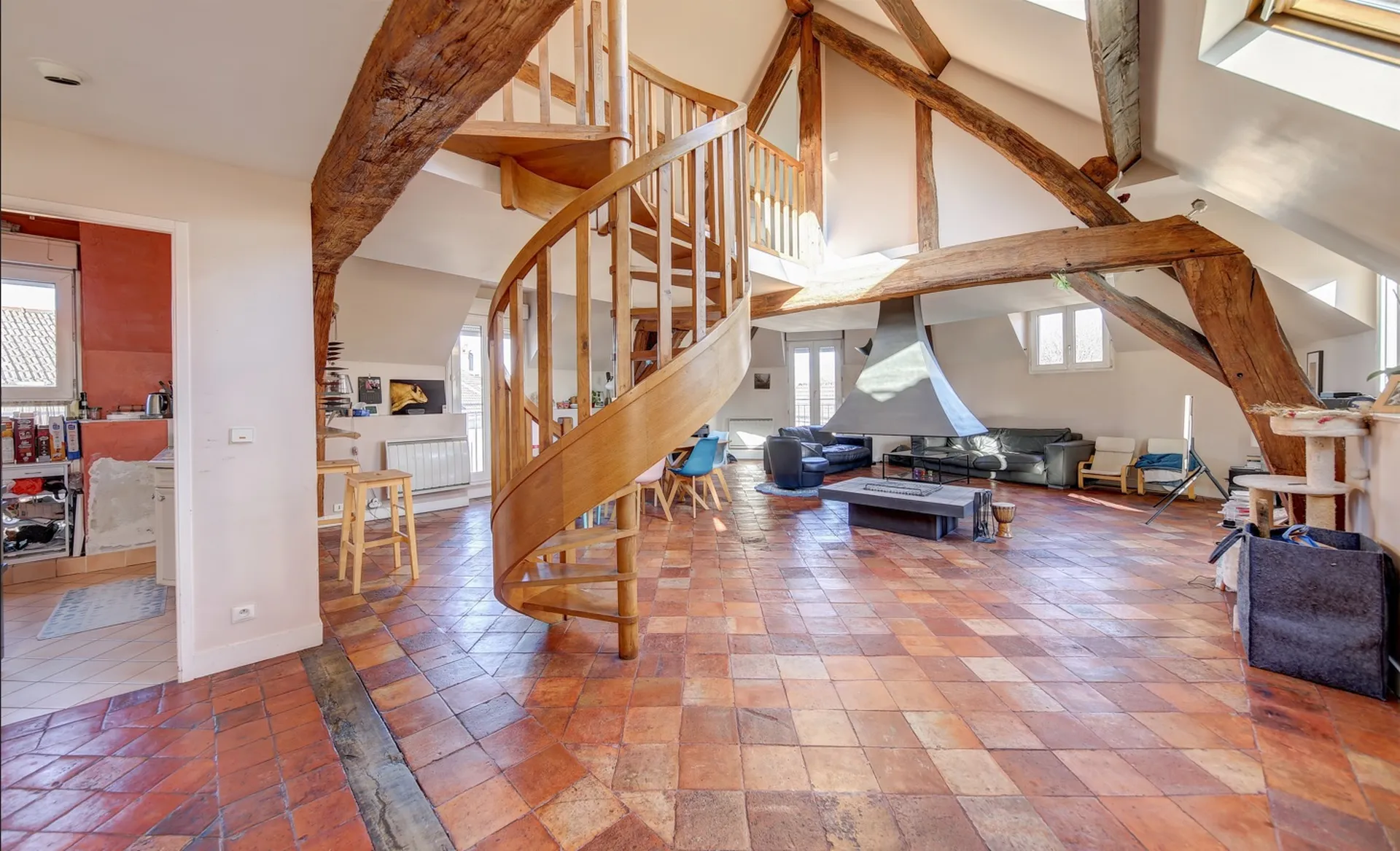 salon ouvert avec cheminée centrale et mezzanine proposé en exclusivité chez Helix immobilier Le Vésinet