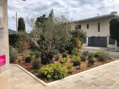 Entrée rénovée à Nice avec travertin et massifs fleuris