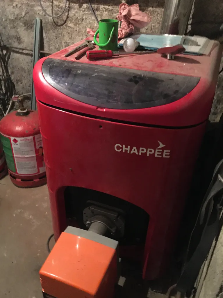 Ancienne chaudière fioul avant remplacement, système de chauffage énergivore et polluant à Châtillon-sur-Chalaronne (Ain 01).