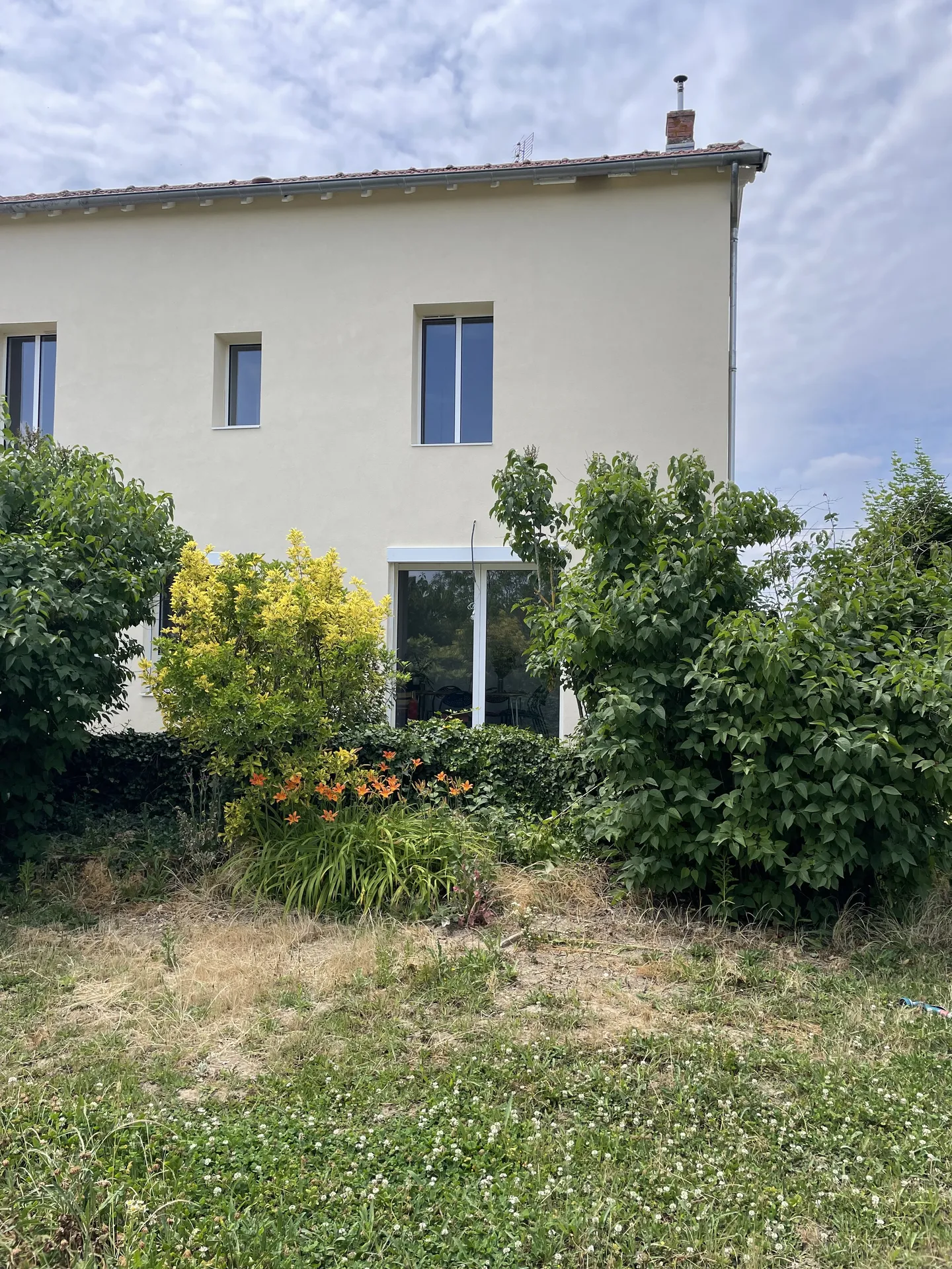Vue extérieure après ouverture du mur porteur avec installation d’une baie vitrée à galandage à Belleville-en-Beaujolais (Rhône – 69), créant un accès direct et lumineux vers l’extérieur