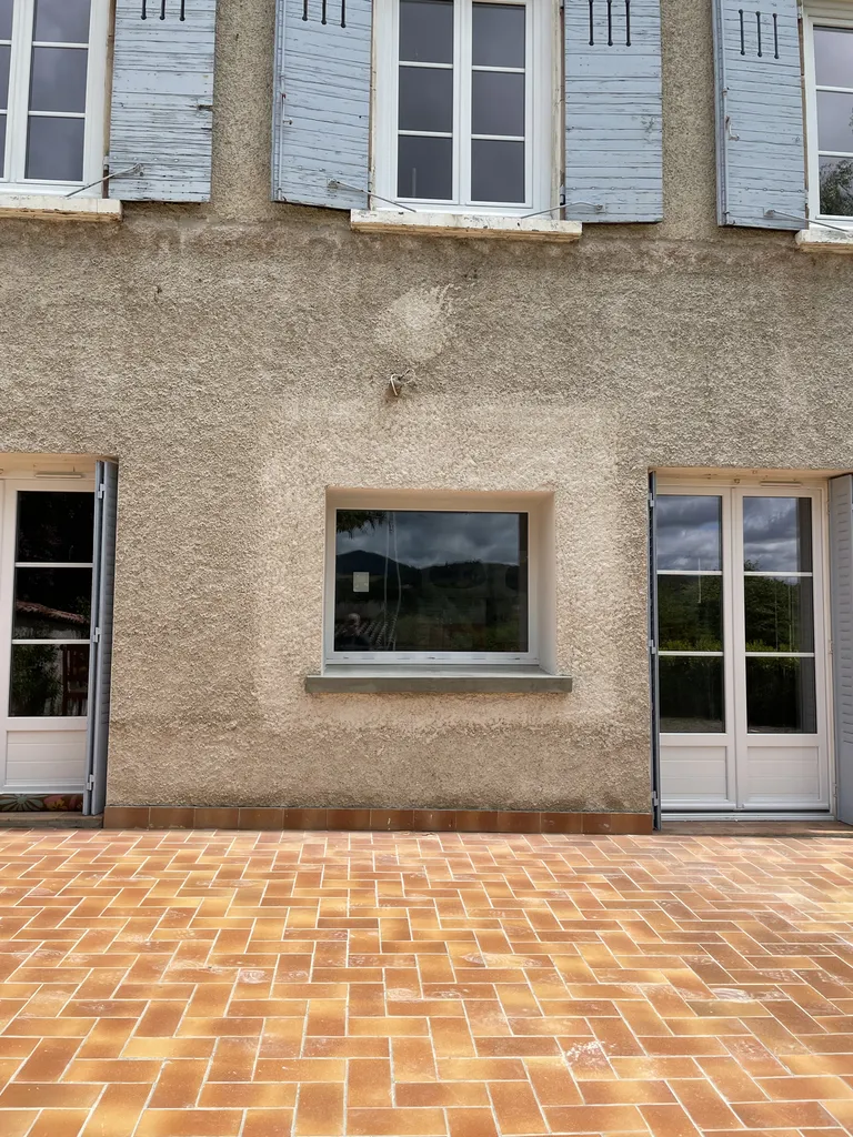 Façade après création de la fenêtre avec reprise complète du crépi, assurant une intégration esthétique parfaite dans le bâti existant