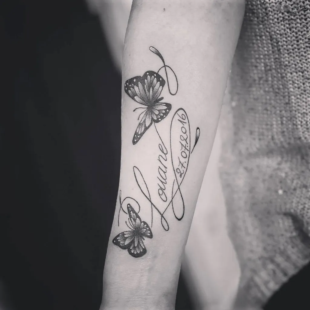 Tatouage sur l'avant bras avec un prénom entouré de papillons à Craponne