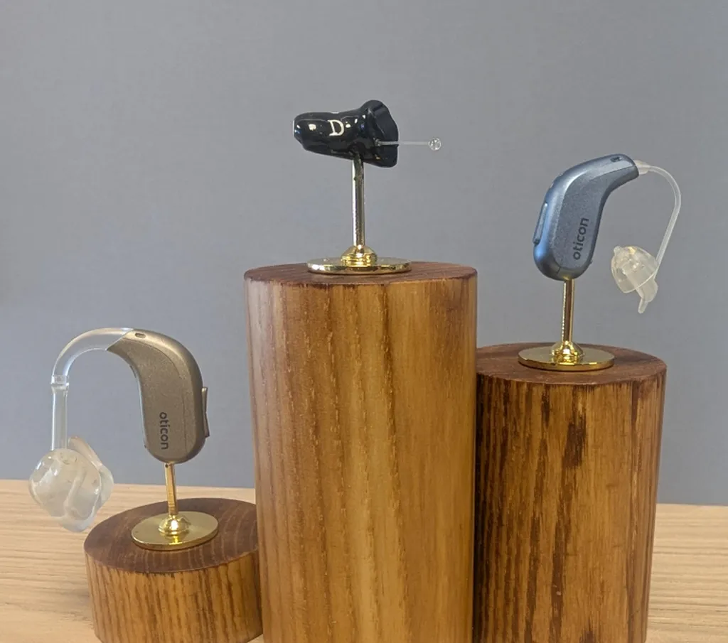 Photo de trois appareils auditifs différents : intra-auriculaire, RIC et contour BTE, présentés par un audioprothésiste à Lyon.