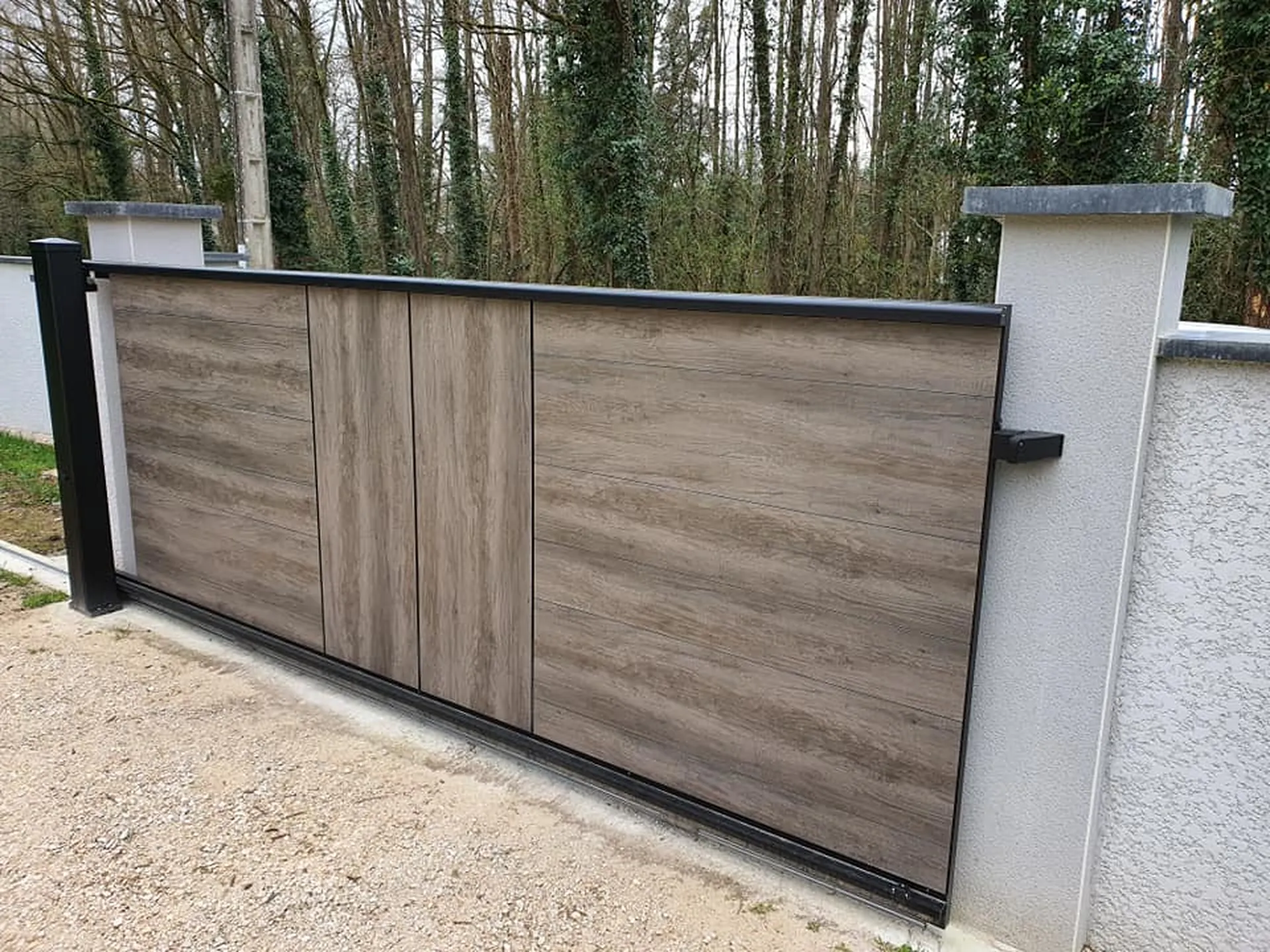 Portail en aluminium ton bois WOODSTOCK bluffant de réalisme assurent une résistance aux UV. La motorisation dans le poteau