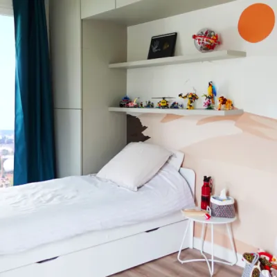 Chambre d’enfant chaleureuse avec rangements sur-mesure et couleurs douces, par l’Atelier D. architecte d’intérieur à Bordeaux.