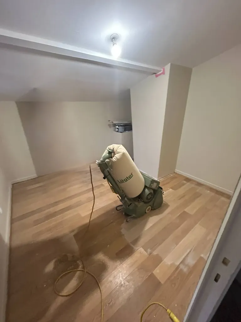 Ponçage du parquet en cours lors de la rénovation intérieure de la maison