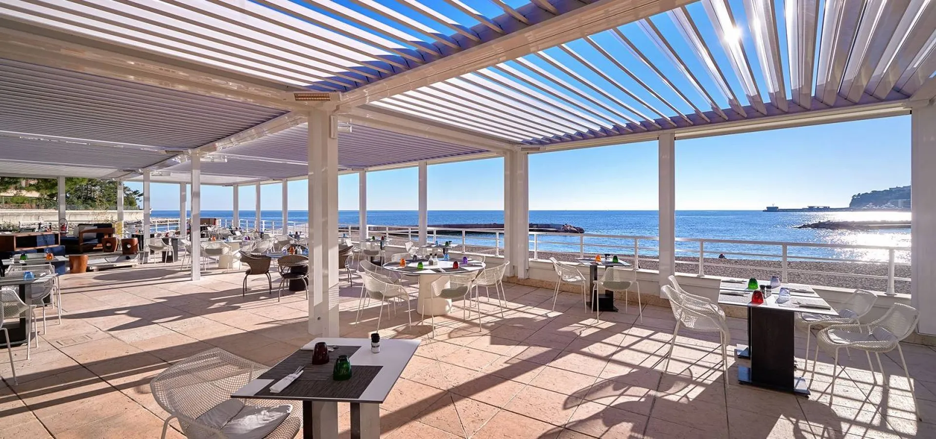 Pose d’une pergola bioclimatique avec système d’ouverture coulissant en verre pour terrasse de restaurant à Martigues
