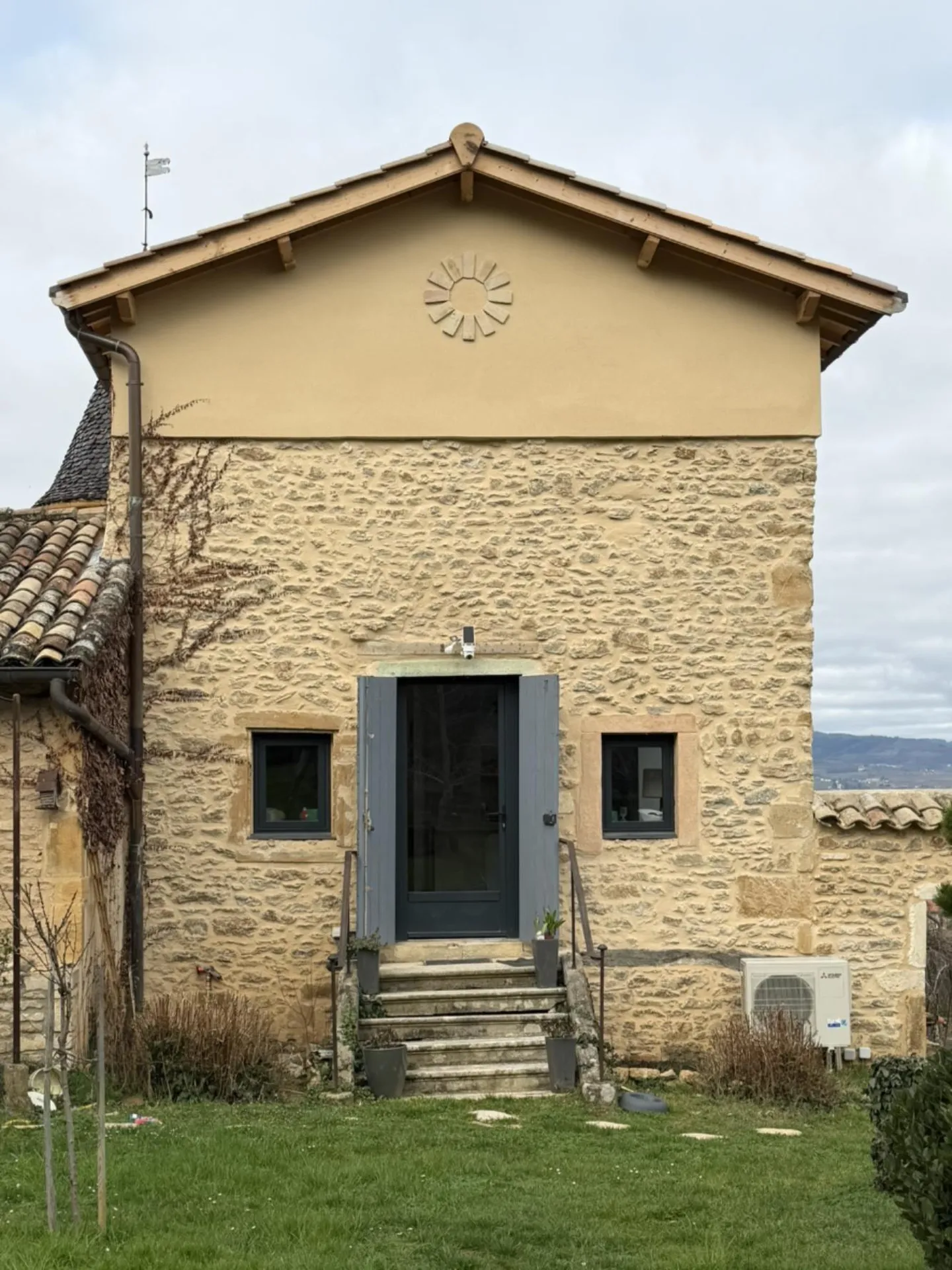 Résultat final : une façade restaurée et sublimée par la création de deux ouvertures symétriques en pierres dorées