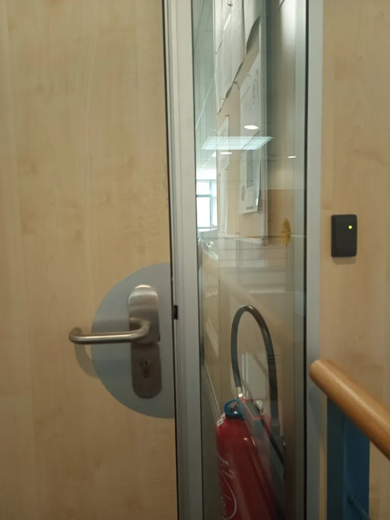 Installation d'une serrure Kel Abloy sur une porte en bois avec mortaisage de la porte pour encastrement de la serrure dans une usine de la Plaine de l'Ain à Lagnieu