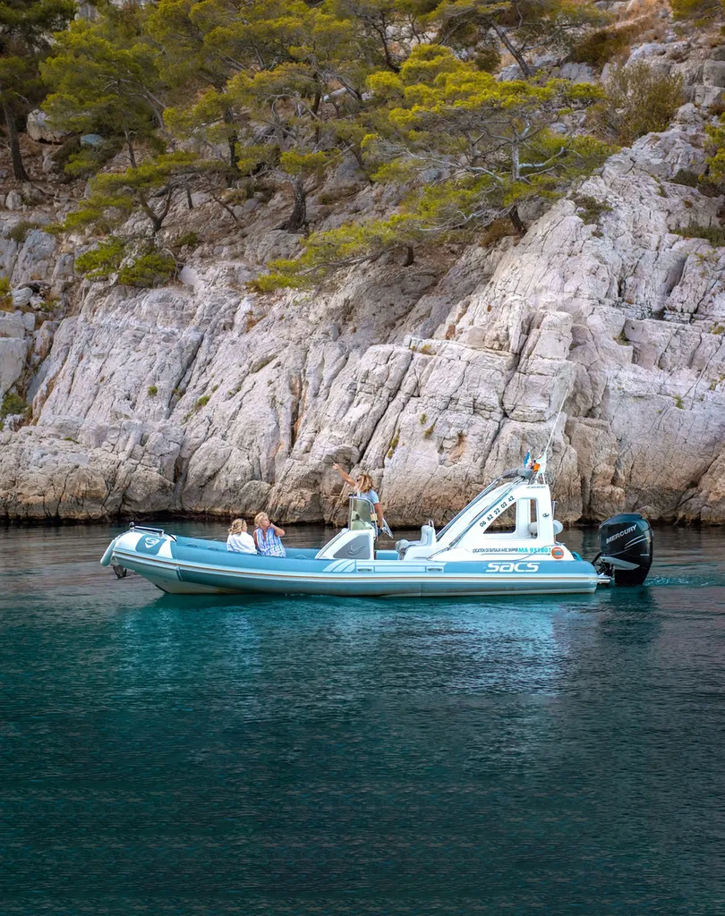 Vue panoramique depuis le pont d'un bateau semi-rigide de L'Eden Boat sur les falaises calcaires des Calanques au départ de Cassis