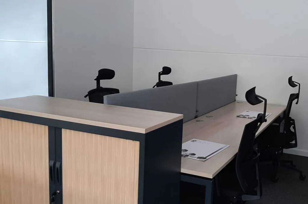 Aménagement de 270 m² de bureaux pour 32 postes à Brignoles avec mobilier ergonomique Made in France, gestion des câbles, acoustique optimisée et identité rouge-noir-bois