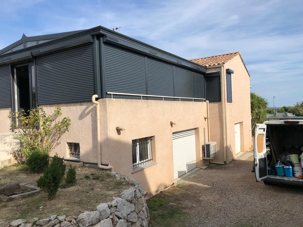 Installation d’une véranda aluminium RAL 7016 avec volets roulants solaires dans la commune de Tourbes – fabrication française