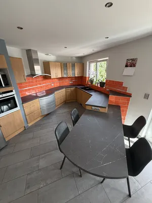 Pose d'un adhésif noir effet marbre sur le plan de travail et la table encastrée 